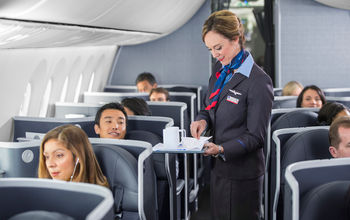 Flight attendant serving coffee aboard an American Airlines flight.