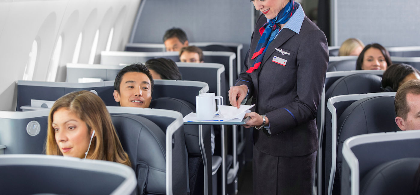 Image: Flight attendant serving coffee aboard an American Airlines flight. (Photo Credit: American Airlines Media)