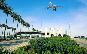 A plane flies above Los Angeles International Airport, LAX