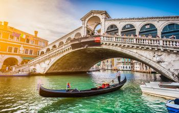 Gondola on Canal Grande with Rialto Bridge at sunset, Venice